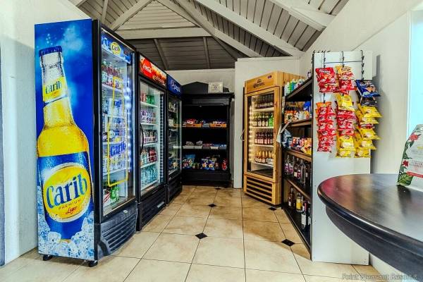 Guest convenience shop at Point Pleasant Resort in St. Thomas, U.S. Virgin Islands, featuring refrigerators stocked with beverages, shelves of snacks and essentials, beer and wine selections, and a small retail area located near the resort lobby.