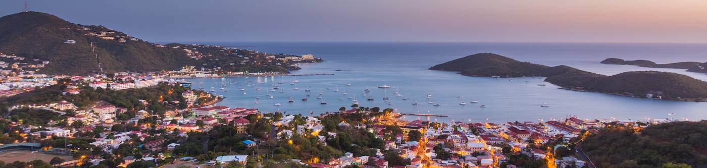 Sunset over the harbor of Charlotte Amalie in St Thomas with view over town and yachts in bay
